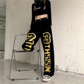 Schwarze, lockere Jeanshose im Streetstyle mit gelbem Buchstaben-Print